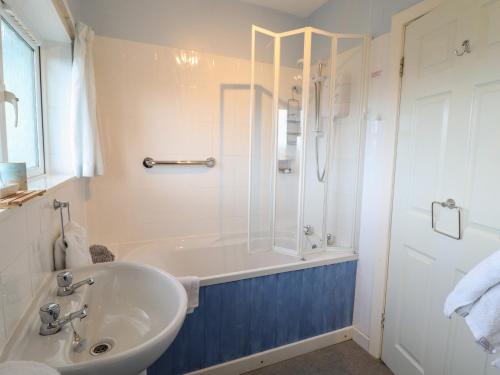 uma casa de banho com uma banheira, um lavatório e um chuveiro em Morlyn Guest House Apartment em Harlech