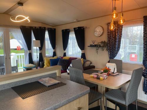 Prestige caravan,Seton Sands holiday village, WiFi في Port Seton: غرفة معيشة مع أريكة وطاولة