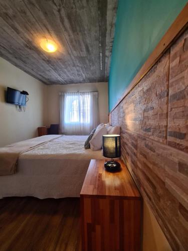 a bedroom with a bed and a table with a lamp at Nova Posada in Colonia del Sacramento