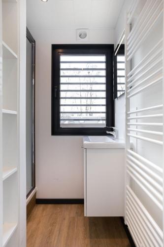a bathroom with a sink and a window at Welcome in - Houseboat 'de Valreep' met tuin - Sneek - Offingawier in Offingawier