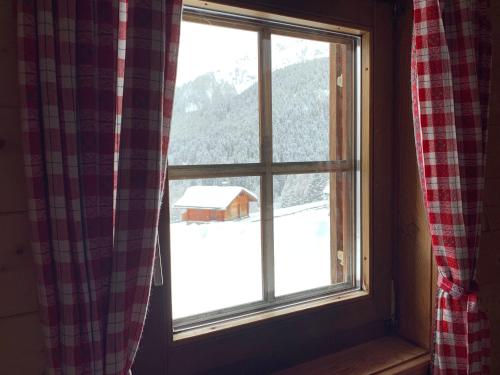 a window with a view of a snow covered barn at Almhuette-Gipper in Heiligenblut