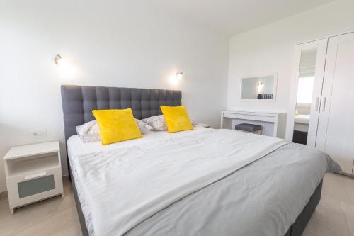 a bedroom with a large bed with two yellow pillows at Apartments Luka in Senj