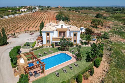 an aerial view of a house with a swimming pool and a vineyard at Quinta Dionysus by Algarve Holidays in Albufeira