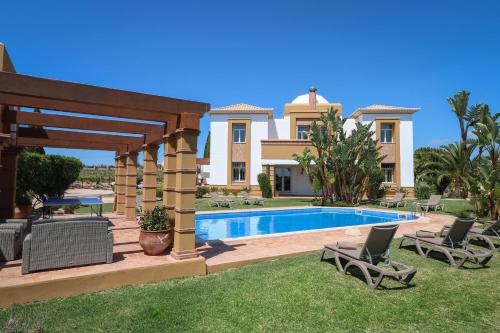 a villa with a swimming pool and a house at Quinta Dionysus by Algarve Holidays in Albufeira