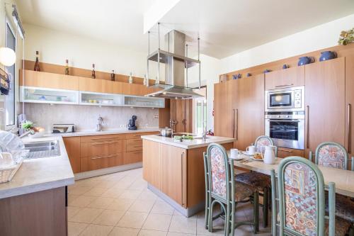 a kitchen with wooden cabinets and a table and chairs at Quinta Dionysus by Algarve Holidays in Albufeira