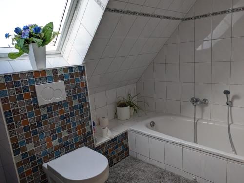 a bathroom with a toilet and a bath tub at Schöne gemütliche Ferienwohnung in Eggebek