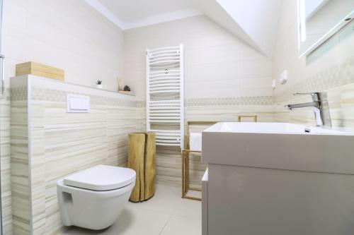 a white bathroom with a toilet and a sink at WOODHOME - Luxury Mountain Apartment Horní Malá Úpa in Horní Malá Úpa