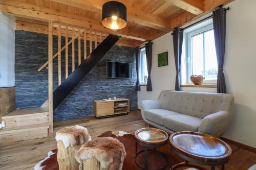 a living room with a couch and a staircase at WOODHOME - Luxury Mountain Apartment Horní Malá Úpa in Horní Malá Úpa