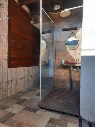 um chuveiro com uma porta de vidro na casa de banho em Suítes Praia Barequeçaba em São Sebastião