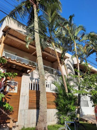 uma casa com palmeiras em frente em Suítes Praia Barequeçaba em São Sebastião