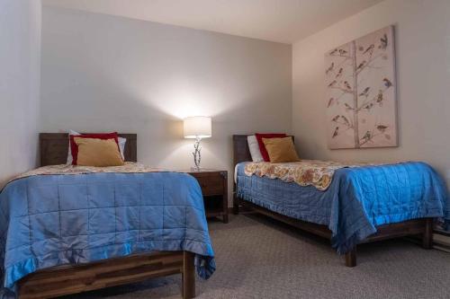 1 dormitorio con 2 camas y una lámpara en la pared en Ski House 251 - Meredith Lodging, en Bend