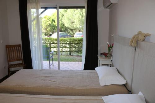Schlafzimmer mit einem Bett und einer Glasschiebetür in der Unterkunft Apartamento, praia, golfe, Lisboa piscina publica com terifa in Almada
