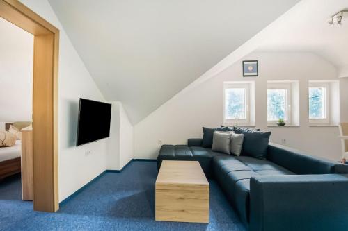 a living room with a blue couch and a tv at Haus Susi in Sautens