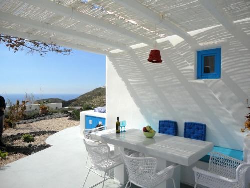 a white patio with a white table and chairs at Illusion Villa - Exceptional Private Villa in Akrotiri