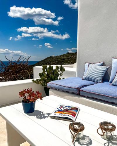 a balcony with a couch and a book on a table at Illusion Villa - Exceptional Private Villa in Akrotiri