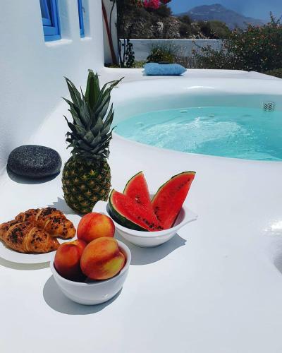 three bowls of fruit on a table next to a swimming pool at Illusion Villa - Exceptional Private Villa in Akrotiri