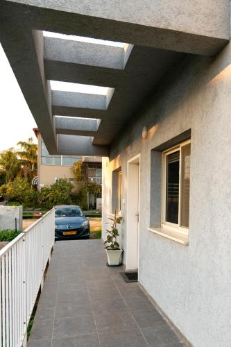 a walkway leading to a house with a car parked at מתחם "חוויה של שקט"- עם בריכה משותפת קרוב לכנרת in Livnim