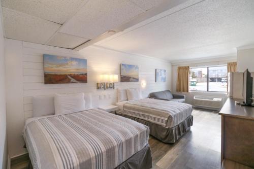 a hotel room with two beds and a television at Atlantic Oceanside Dewey in Dewey Beach
