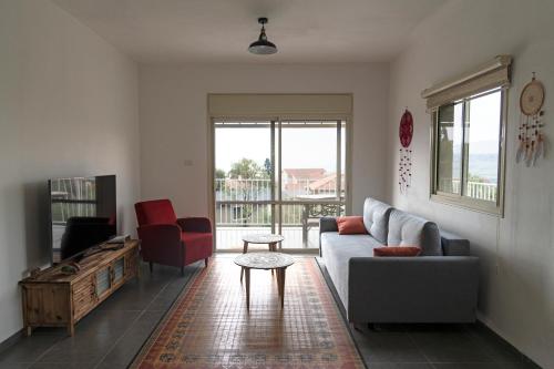 a living room with a couch and a table at מתחם "חוויה של שקט"- עם בריכה משותפת קרוב לכנרת in Livnim