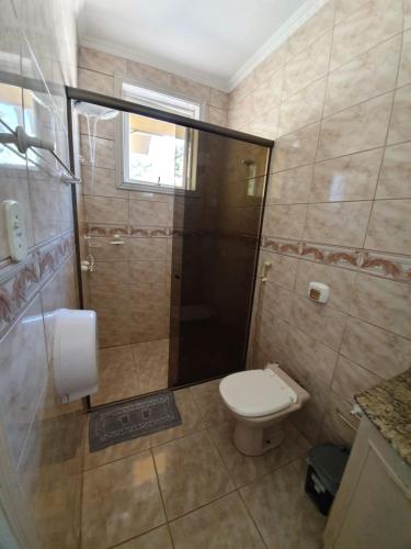 a small bathroom with a toilet and a shower at Pousada Pedra das Tartarugas in São Francisco do Sul