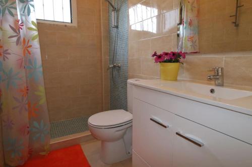 a bathroom with a toilet and a sink and a shower at Casinha; Piscina/ Praia/ Lisboa in Aroeira