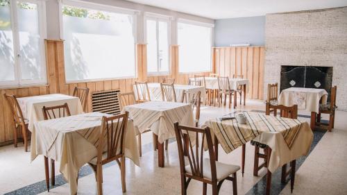 a dining room with tables and chairs and a fireplace at Aires Patagónicos in El Bolsón