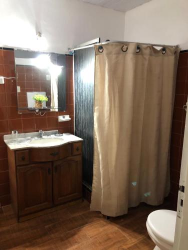 a bathroom with a shower curtain and a sink at Casa en el Real de san carlos in Colonia del Sacramento