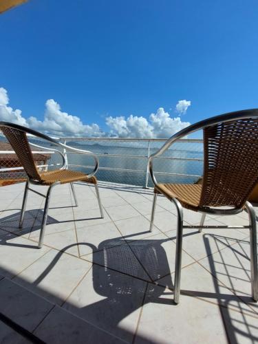two chairs sitting on a balcony with a view of the ocean at Pousada Pedra das Tartarugas in São Francisco do Sul