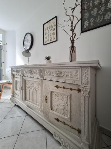 a white cabinet in a room with a clock on the wall at Gîte du Vieux Château in Carvin