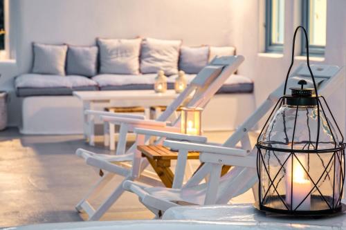a living room with two chairs and a table with a lantern at Illusion Villa - Exceptional Private Villa in Akrotiri
