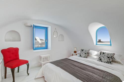 a bedroom with a bed and a red chair at Illusion Villa - Exceptional Private Villa in Akrotiri