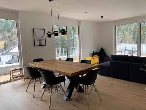 a living room with a wooden table and chairs at Das Taja Paznaun Penthouse Apartments in See