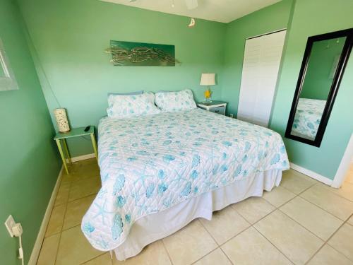 a bedroom with a bed and green walls at #808 Gulf View at Lovers Key Beach Club in Fort Myers Beach