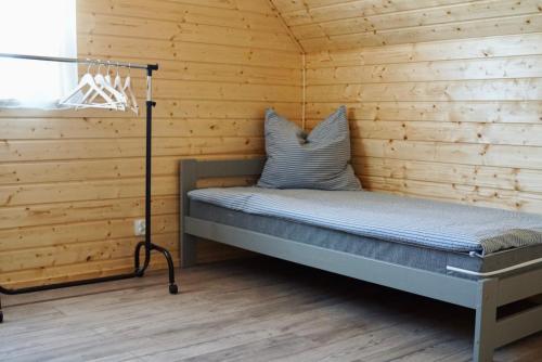 ein Schlafzimmer mit einem Bett in einer Holzwand in der Unterkunft Hostel Przystan in Rościno