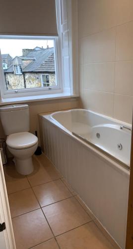 un bagno con vasca, WC e finestra di The Curious Fox a Skipton
