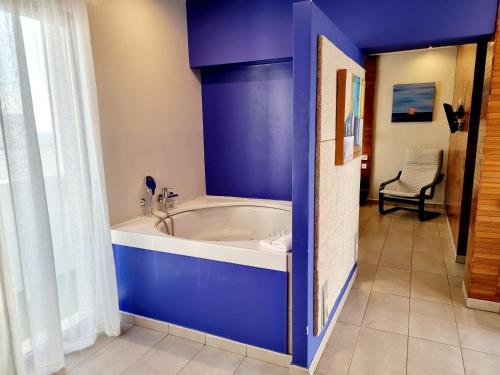 Habitación con baño azul con bañera. en Apartamentos El Arrecife, en Conil de la Frontera