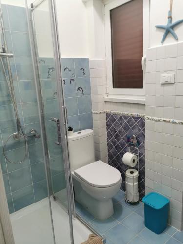 a bathroom with a toilet and a glass shower at Il Mare di Delfy in Lido di Ostia
