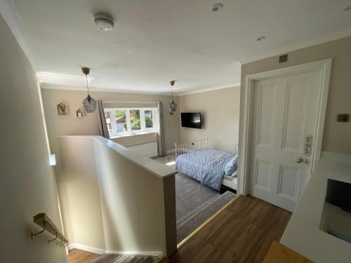 a small bedroom with a bed and a stairway at Avondale, Lytham - Unique and luxury apartment in the heart of Lytham in Lytham St Annes