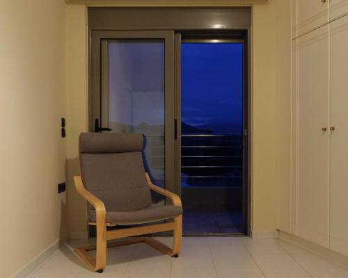 una silla en una habitación con vistas al océano en Apartment Lazarous 2 en Apolakkiá