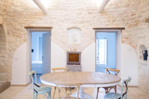 comedor con mesa de madera y sillas en Trullo e Suites Parini 32, en Alberobello