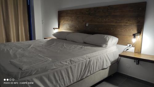 a bedroom with a bed with a wooden headboard at Carpe diem in Galatas