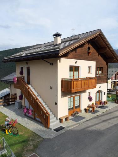 uma pequena casa com uma varanda e um deque em Baita Mauri em Livigno