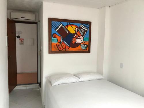 a painting on the wall above a bed in a room at Pousada Suítes Do Pelô in Salvador
