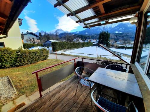 a balcony with a table and chairs and a view at Chalet Dobratsch in Latschach