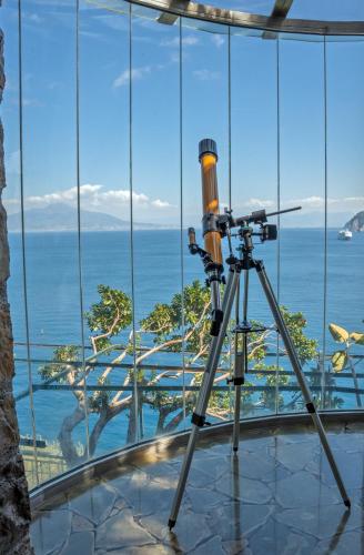 a telescope on a tripod in front of a window at Hotel Belair in Sorrento