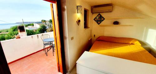 1 Schlafzimmer mit einem Bett und einem Balkon mit einem Tisch in der Unterkunft Residenza Citronella in Macari