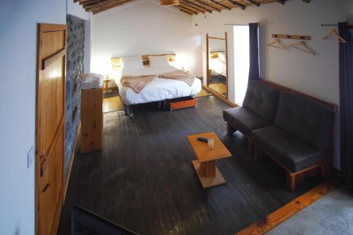 a bedroom with a bed and a couch in a room at Aldeia Dos Caldeirões in São Mateus