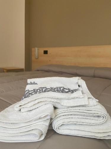 un grupo de toallas sentadas encima de una cama en Bed & Breakfast Memory, en Canzano