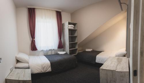 a hotel room with two beds and a window at Navigator in Palić