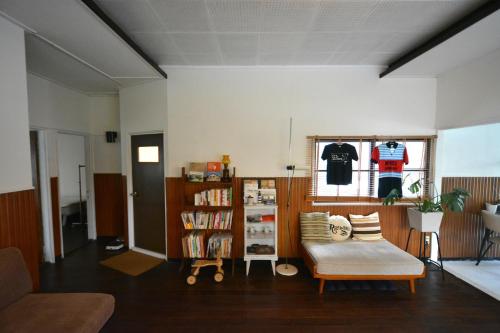 Fukuoka - House - Vacation STAY 4674 في فوكوكا: غرفة معيشة مع كرسي ورف كتاب
